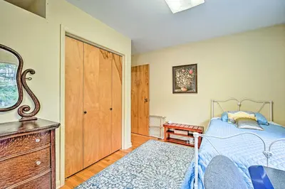 a bedroom with a bed and a dresser and a mirror at Family Winter Retreat with Hot Tub 14 Mi to Slopes! in Whitingham