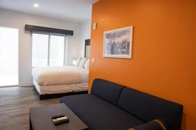 a living room with a bed and a couch at Peachtree Suites - Jersey City in Jersey City