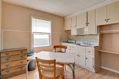 a kitchen with white cabinets and a table and chairs at Kayaks and Canoes Lake-View Retreat in Ellenville! in Ellenville
