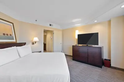 a hotel room with a bed and a flat screen tv at Harmony Suites Secaucus Meadowlands in Secaucus