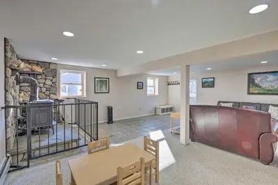 a living room with a table and a stone wall at Family-Friendly Woodbury Home with Yard and Deck! in Woodbury
