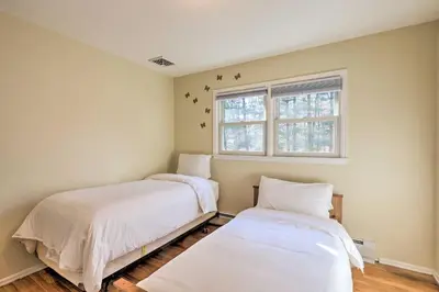 two beds in a room with a window at Family-Friendly Woodbury Home with Yard and Deck! in Woodbury