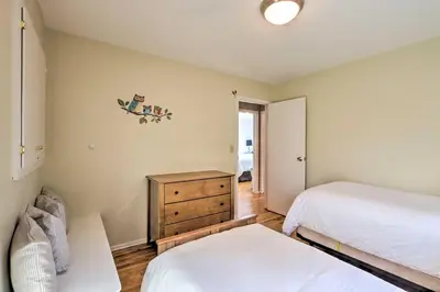 a bedroom with two beds and a wooden dresser at Family-Friendly Woodbury Home with Yard and Deck! in Woodbury