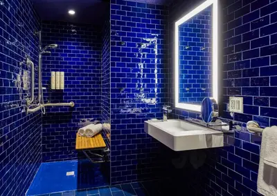 a blue tiled bathroom with a sink and a mirror at Radio Hotel in New York