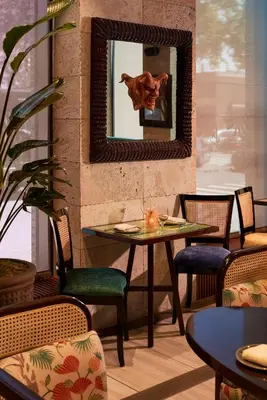 a mirror on a wall with a table and chairs at Radio Hotel in New York