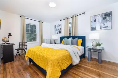 a bedroom with a blue bed with a yellow blanket at Lovely Ranch House in Windsor, 10 mins to Hartford Connecticut in Windsor
