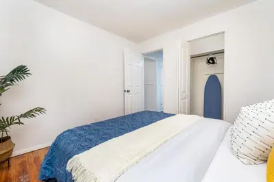a white bedroom with a blue and white bed at Lovely Ranch House in Windsor, 10 mins to Hartford Connecticut in Windsor