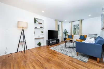 a living room with a blue couch and a tv at Lovely Ranch House in Windsor, 10 mins to Hartford Connecticut in Windsor