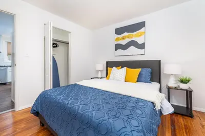 a bedroom with a bed with blue and yellow pillows at Lovely Ranch House in Windsor, 10 mins to Hartford Connecticut in Windsor