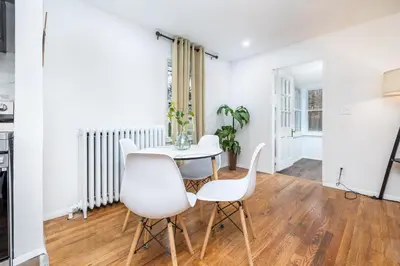 a white dining room with a table and white chairs at Lovely Ranch House in Windsor, 10 mins to Hartford Connecticut in Windsor