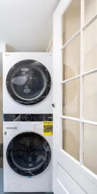 a washer and dryer in a room with a window at Lovely Ranch House in Windsor, 10 mins to Hartford Connecticut in Windsor