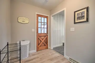 a hallway with a wooden door and a laundry room at Modern Studio Less Than 13 Mi to Saratoga Racetrack! in Ballston Spa