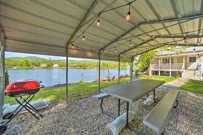 a covered patio with a grill and a table at Lake Luzerne Home with Fire Pit on Hudson River in Lake Luzerne
