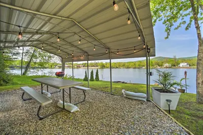 a patio with a table and chairs and a view of a lake at Lake Luzerne Home with Fire Pit on Hudson River in Lake Luzerne