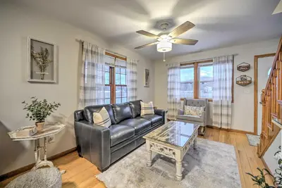 a living room with a leather couch and a table at Lake Luzerne Home with Fire Pit on Hudson River in Lake Luzerne