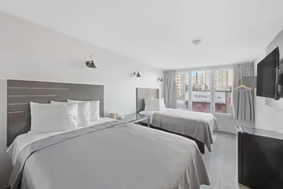 a hotel room with two beds and a television at Hotel TREMONT Bronx Yankee Stadium in Bronx