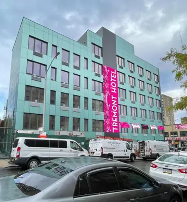 a large building with cars parked in front of it at Hotel TREMONT Bronx Yankee Stadium in Bronx