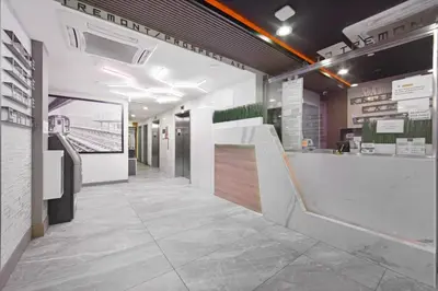 a lobby of a building with a staircase and a counter at Hotel TREMONT Bronx Yankee Stadium in Bronx