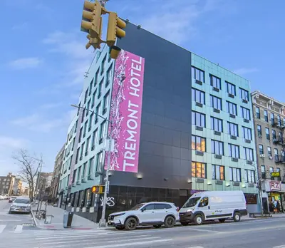 a building with a pink sign on the side of it at Hotel TREMONT Bronx Yankee Stadium in Bronx