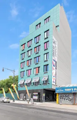 a large blue building with a car parked in front of it at Hotel 365 Bronx - Yankee Stadium in Bronx