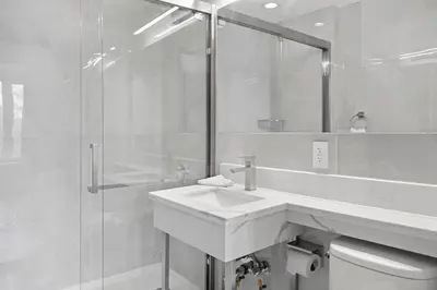 a white bathroom with a sink and a shower at Hotel 365 Bronx - Yankee Stadium in Bronx