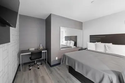 a bedroom with a bed and a desk and a mirror at Hotel 365 Bronx - Yankee Stadium in Bronx