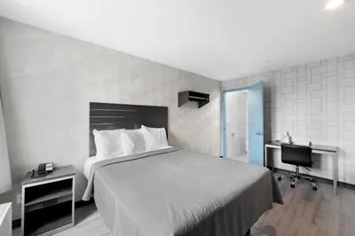 a bedroom with a bed and a desk and a computer at Hotel 365 Bronx - Yankee Stadium in Bronx