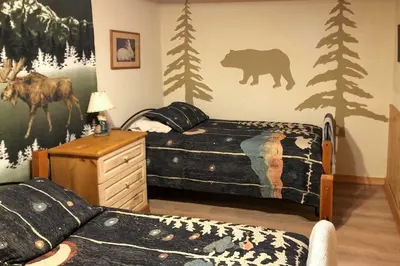 a bedroom with a bed and a bear mural on the wall at Pet-Friendly New York Cabin with Hot Tub and Game Room in Maplecrest