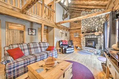 a living room with a couch and a fireplace at Pet-Friendly New York Cabin with Hot Tub and Game Room in Maplecrest