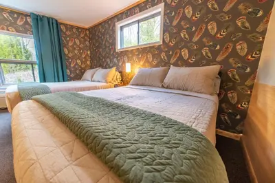 a bedroom with a large bed in a room with wallpaper at The Springs Motel in New Ashford
