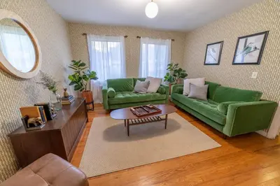a living room with two green couches and a table at The Springs Motel in New Ashford