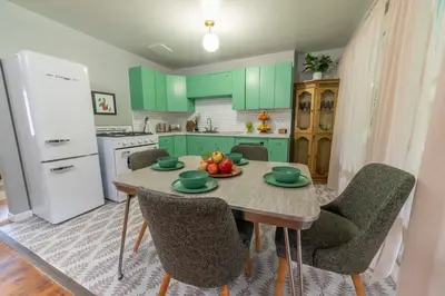 a kitchen with green cabinets and a table with fruit on it at The Springs Motel in New Ashford
