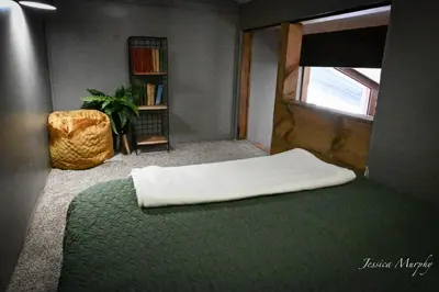 a bedroom with a bed and a book shelf at The Springs Motel in New Ashford