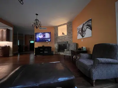 a living room with a couch and a tv at 9 Bedroom Saratoga Retreat, In-Ground Heated Pool, HotTub, Firepit, Gourmet Kitchen, Private Office in Saratoga Springs