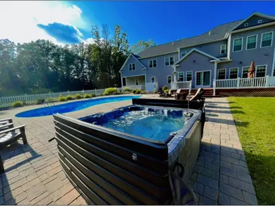 a house with a swimming pool in the yard at 9 Bedroom Saratoga Retreat, In-Ground Heated Pool, HotTub, Firepit, Gourmet Kitchen, Private Office in Saratoga Springs