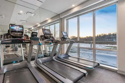 a gym with cardio machines and a large window at Global Luxury Suites Downtown White Plains in White Plains