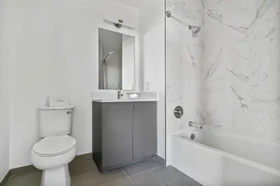 a bathroom with a toilet and a tub and a sink at Global Luxury Suites Downtown White Plains in White Plains