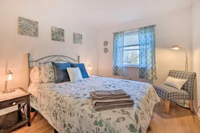 a bedroom with a bed and a chair and a window at 4 Mi to Tobyhanna State Park Home with Fire Pit in Tobyhanna
