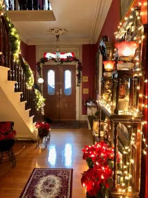 a living room with christmas lights and a door at Raindrops On Roses Bed & Breakfast in Herkimer