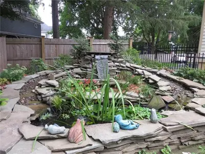 a garden with a water fountain in a yard at Raindrops On Roses Bed & Breakfast in Herkimer