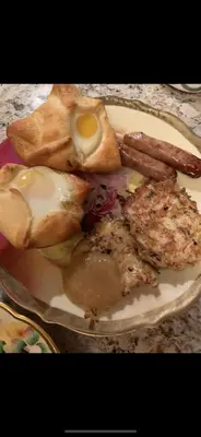 a plate of breakfast food with an egg and sausage at Raindrops On Roses Bed & Breakfast in Herkimer