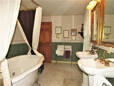 a bathroom with two sinks and a bath tub and a tub at Raindrops On Roses Bed & Breakfast in Herkimer