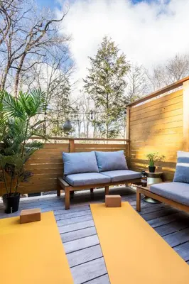 a patio with two benches and a wooden fence at The Herwood Inn in Woodstock