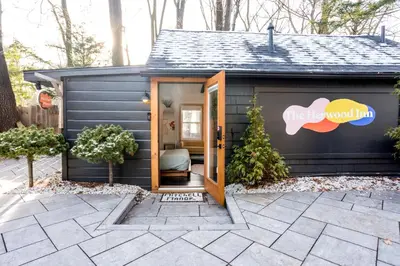 a black tiny house with the door open at The Herwood Inn in Woodstock