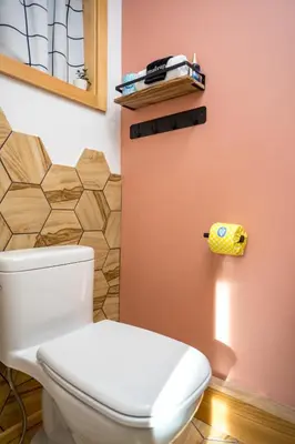 a bathroom with a white toilet and a wall at The Herwood Inn in Woodstock