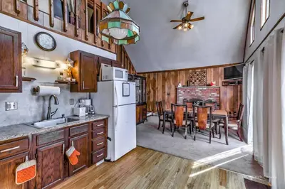 a kitchen and dining room with a white refrigerator at Beautiful Chalet with Hot Tub & Sauna in Poconos in Long Pond