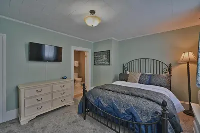 a bedroom with a bed and a tv on the wall at Tom Quick Inn in Milford