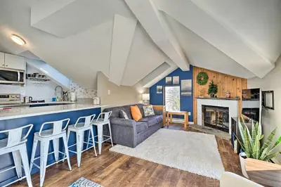 a living room with a couch and a kitchen at Steps to Ski Shuttle! Snow Mountain Village Condo in Dover