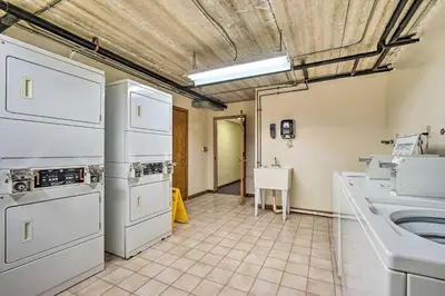 a kitchen with white appliances and a sink at Steps to Ski Shuttle! Snow Mountain Village Condo in Dover