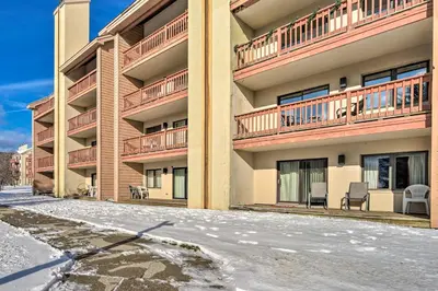 an apartment building with snow in front of it at Steps to Ski Shuttle! Snow Mountain Village Condo in Dover